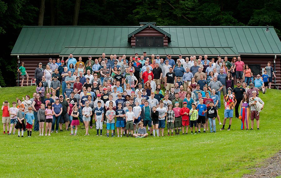 Group photo of open house and carnival participants in front of cabin